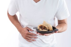 A man clutches his stomach due to food poisoning symptoms. 