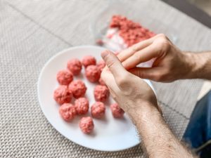 Harmful bacteria is found in raw meat and spread by handling it with bare hands. 