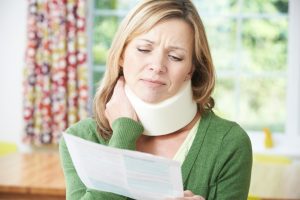 A woman in a neck brace reading a document