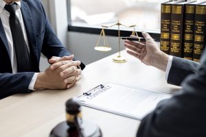 Two solicitors talk about groin injury claims at a desk. 