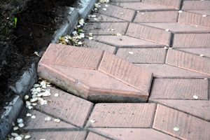 A loose paving slab sitting above a pavement.