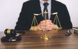 A cruise ship injury lawyer sitting behind a wooden desk and golden scales